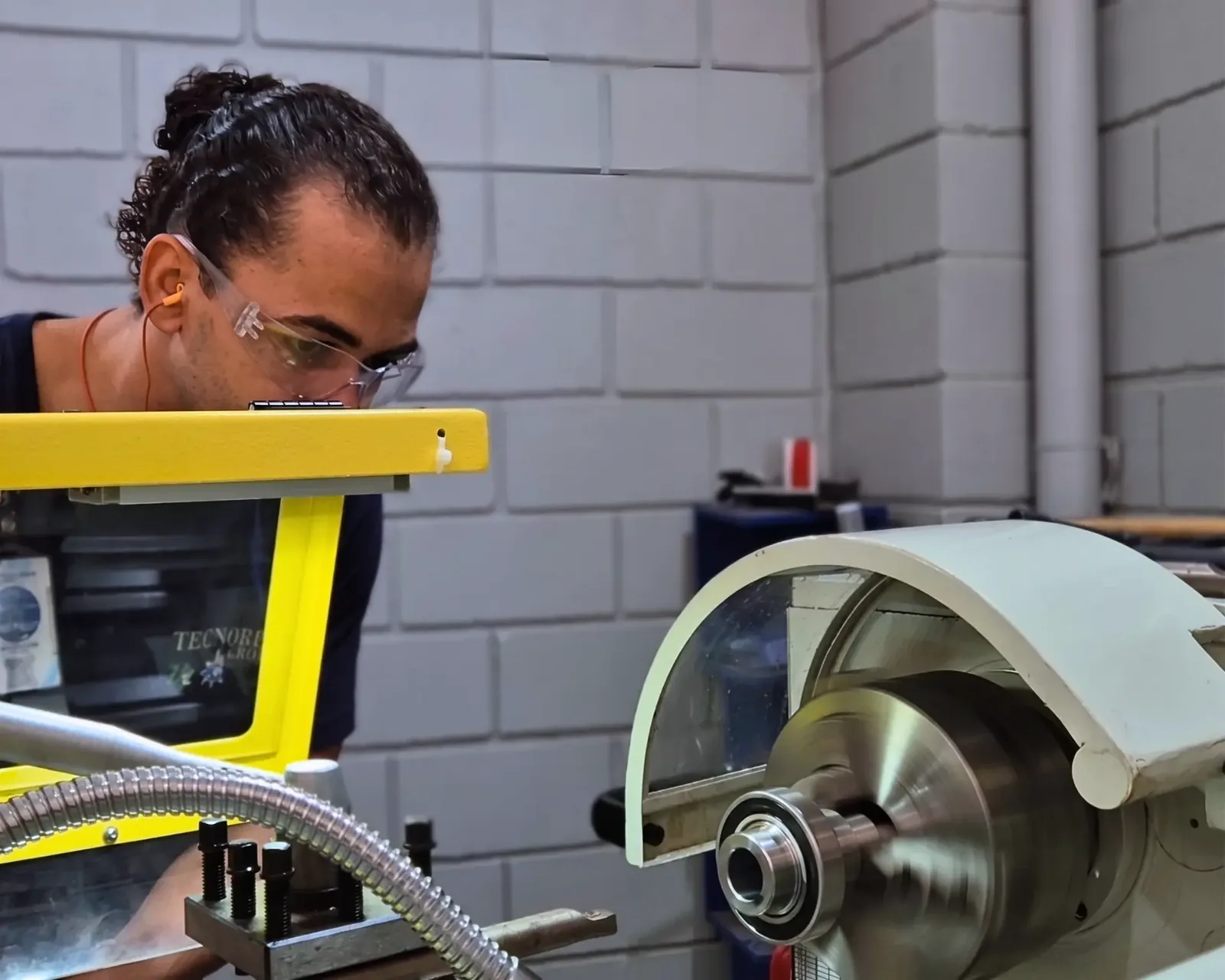 Técnico da Tecnored usinando um componente de redutor em torno na oficina